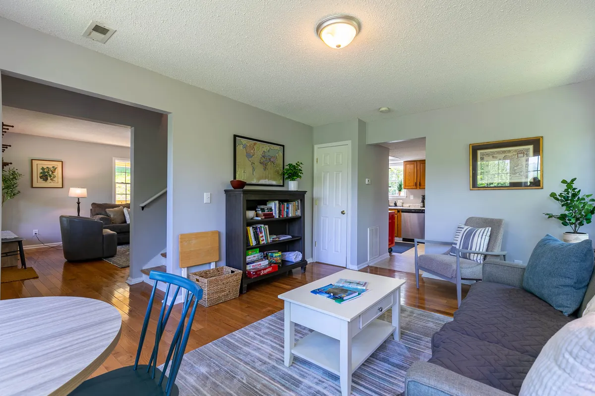 A versatile den area with a sofa, coffee table, bookshelf, and a map on the wall, creating an inviting nook for reading, relaxing, or accommodating extra guests. The setup suggests flexibility and comfort for both group activities and private downtime.